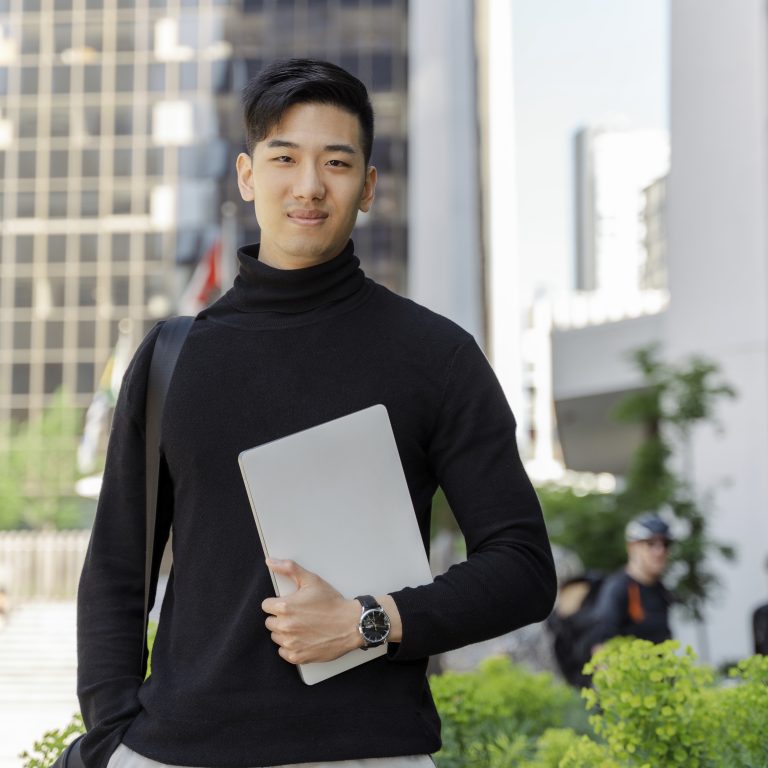 Confident asian businessman holding digital tablet, looking at camera on street, outdoors. Smiling chinese student studying near university campus. Education concept